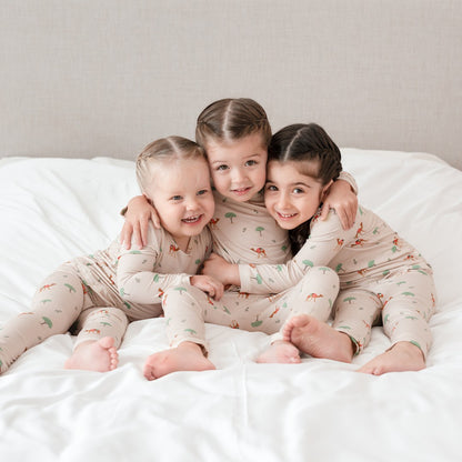 Hushabye camel print bamboo rayon pajamas on three children sitting on a white bed. Soft, breathable, OEKO-TEX® certified.