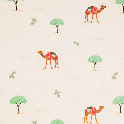 Hushabye camel print bamboo rayon pajamas for kids. Features a cream background with a repeating pattern of camels with red and green blankets, green trees, and desert landscape.