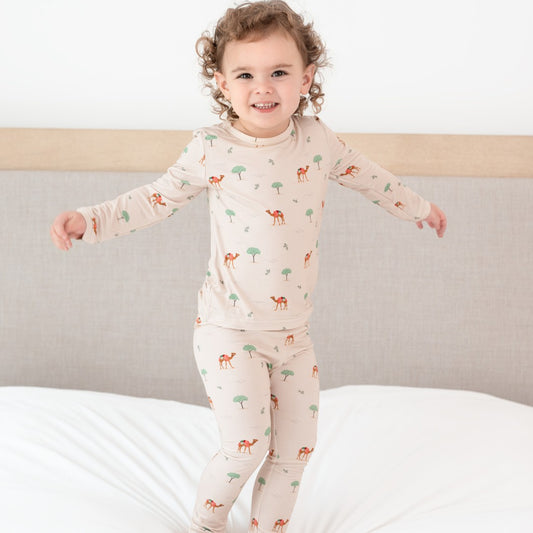 Hushabye camel print bamboo rayon pajamas for toddlers. Long sleeve top and pants in a light tan with camel and tree pattern.
